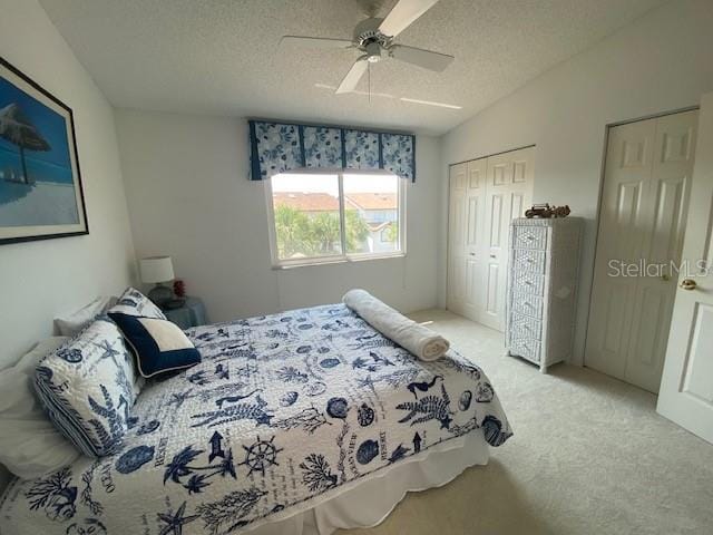 bedroom featuring a textured ceiling, lofted ceiling, carpet flooring, and ceiling fan