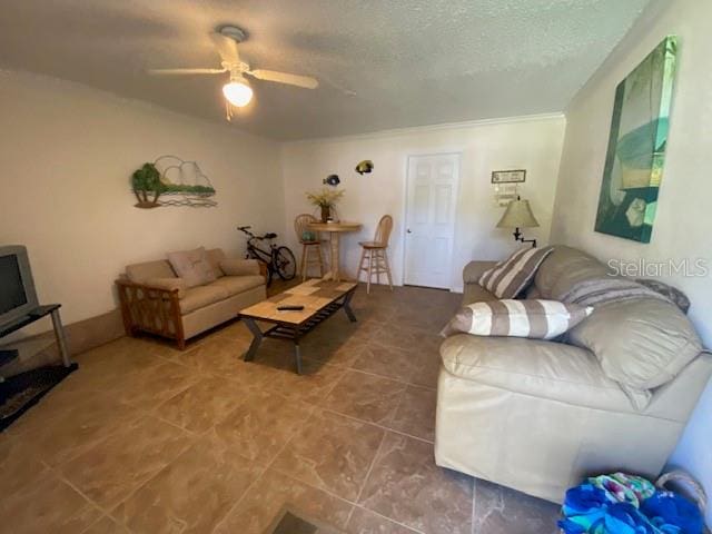 tiled living room with ceiling fan and a textured ceiling