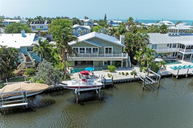 back of house with a water view and a patio area