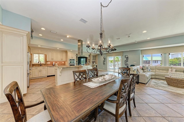 dining area featuring a notable chandelier, a wealth of natural light, and light tile floors