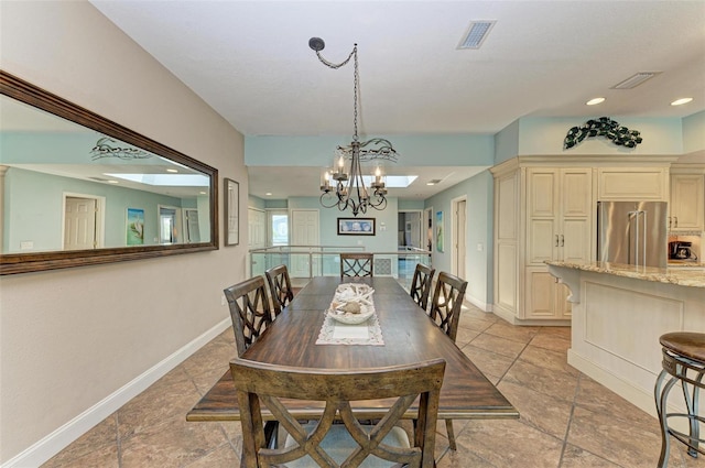 tiled dining space featuring a notable chandelier