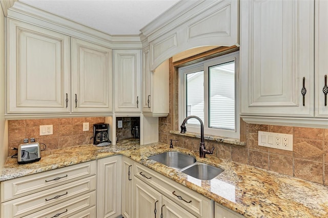 kitchen with sink, tasteful backsplash, and light stone counters