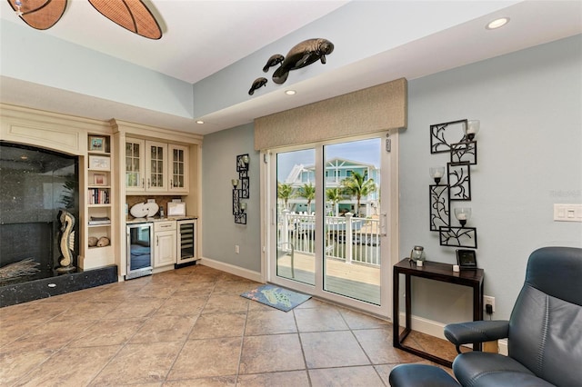 interior space featuring light tile flooring, beverage cooler, and a fireplace