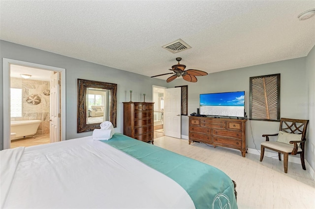 bedroom featuring ensuite bath, ceiling fan, and a textured ceiling