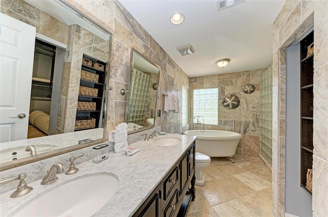 bathroom with dual sinks, separate shower and tub, tile walls, built in features, and tile floors