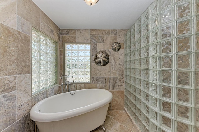 bathroom with tile flooring, tile walls, and independent shower and bath