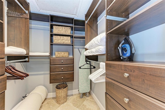 walk in closet featuring light tile floors