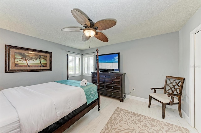 bedroom featuring a textured ceiling, ceiling fan, and light hardwood / wood-style flooring