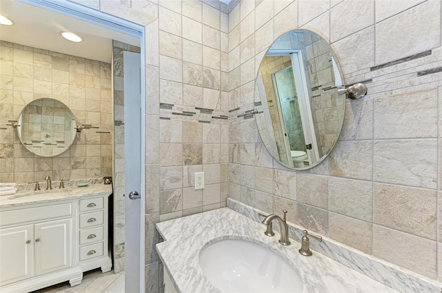 bathroom with tile flooring, tile walls, and vanity