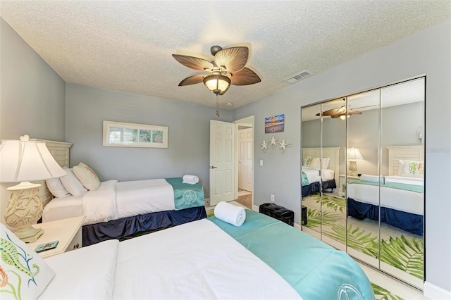 bedroom featuring ceiling fan, a closet, and a textured ceiling