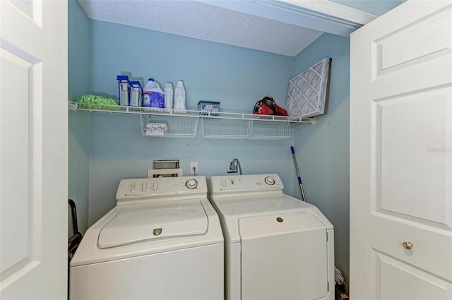 clothes washing area featuring washer and dryer, a textured ceiling, hookup for a washing machine, and electric dryer hookup