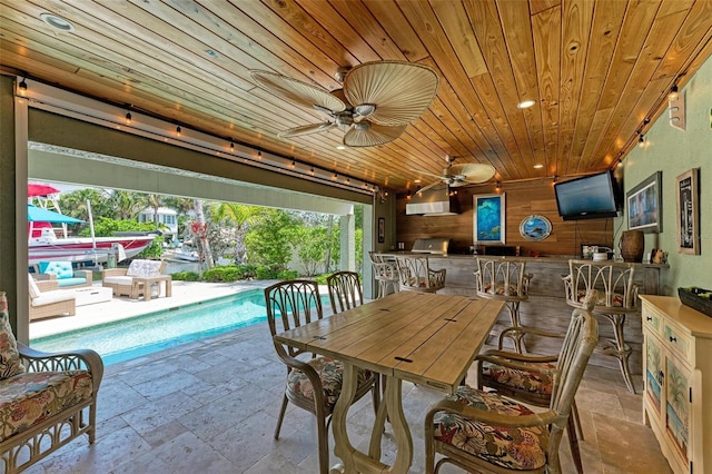 view of terrace with exterior bar and ceiling fan