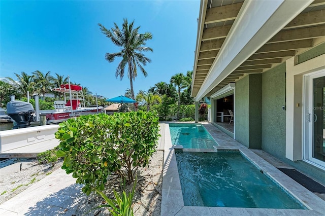 view of swimming pool featuring a patio area and an in ground hot tub