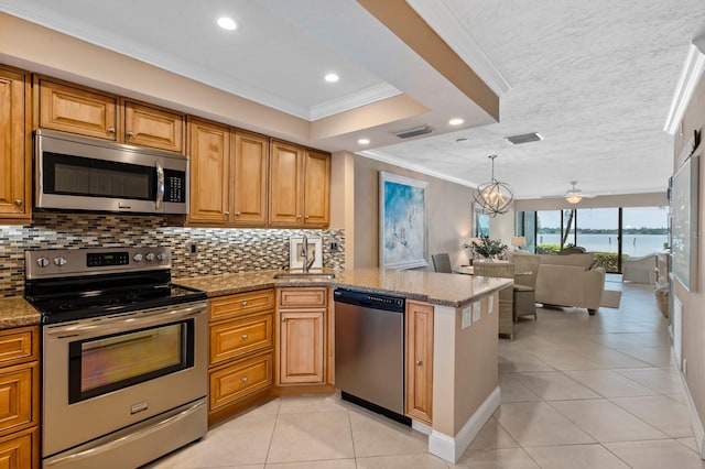 kitchen with crown molding, stainless steel appliances, a water view, stone counters, and sink