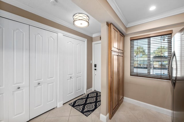 tiled entryway featuring crown molding