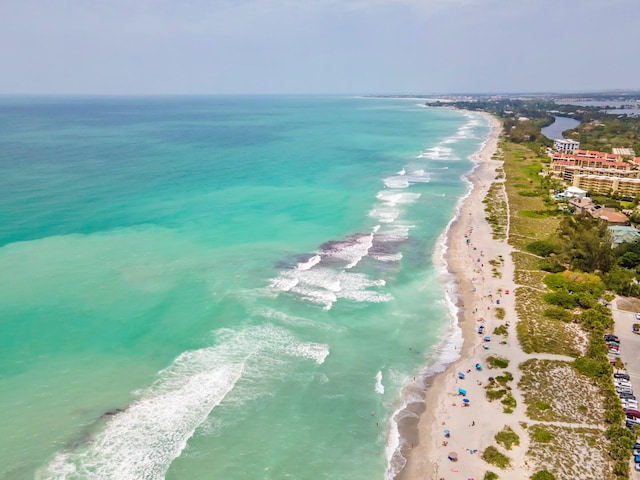 drone / aerial view featuring a beach view and a water view