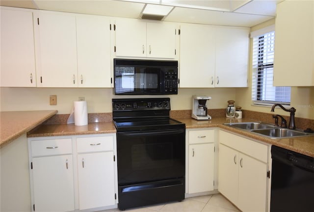 kitchen with black appliances, sink, white cabinets, and light tile floors