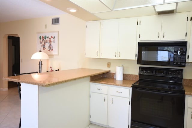 kitchen with black appliances, white cabinets, kitchen peninsula, and light tile floors