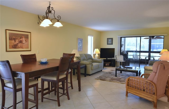 dining space featuring light tile floors and ceiling fan with notable chandelier