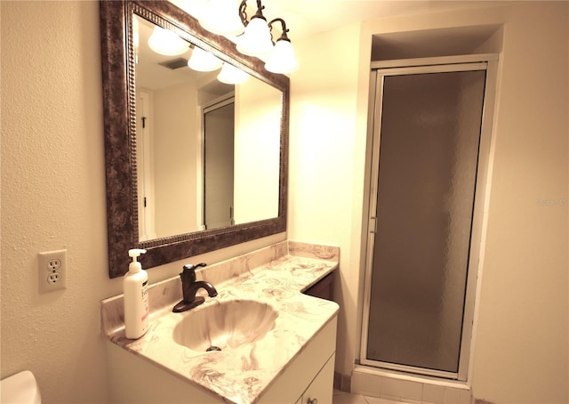 bathroom featuring a shower with shower door and vanity with extensive cabinet space