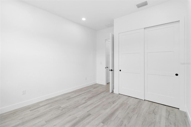 unfurnished bedroom featuring a closet and light hardwood / wood-style floors