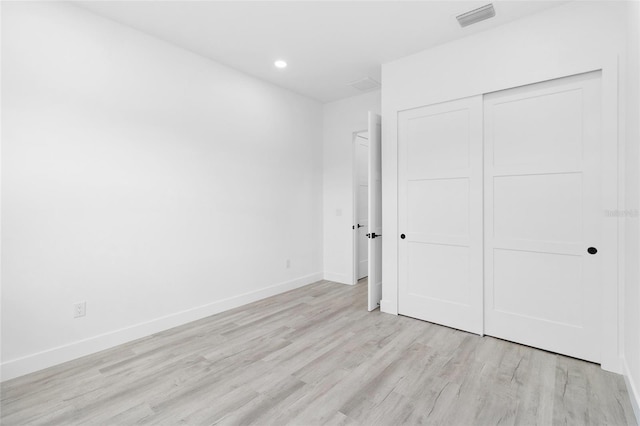 unfurnished bedroom with light wood-type flooring, visible vents, recessed lighting, a closet, and baseboards