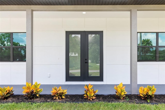 view of exterior entry with french doors and stucco siding