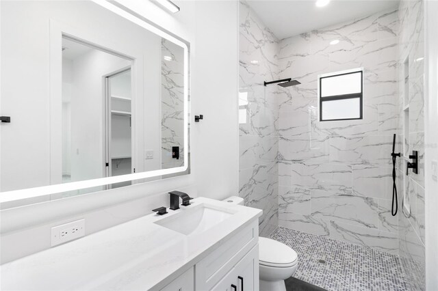 full bathroom featuring a marble finish shower, toilet, and vanity