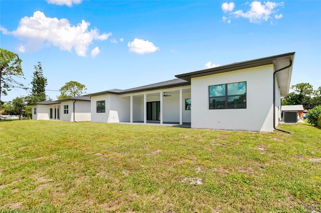 rear view of house featuring central AC unit, a patio, and a yard