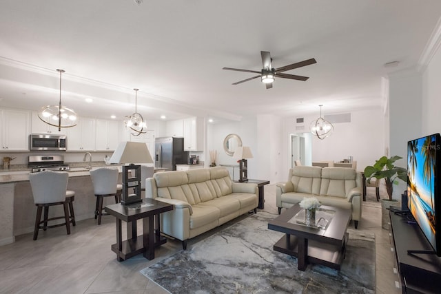 living room featuring sink, ceiling fan with notable chandelier, ornamental molding, and light tile floors