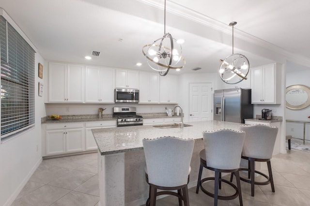 kitchen with white cabinetry, appliances with stainless steel finishes, an island with sink, decorative light fixtures, and sink