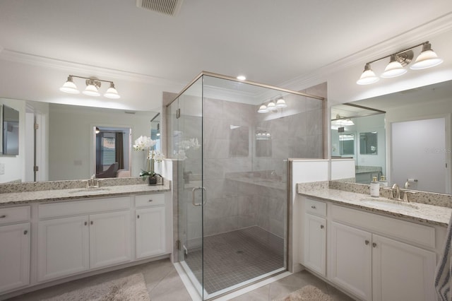 bathroom with tile flooring, ornamental molding, vanity with extensive cabinet space, and a shower with shower door