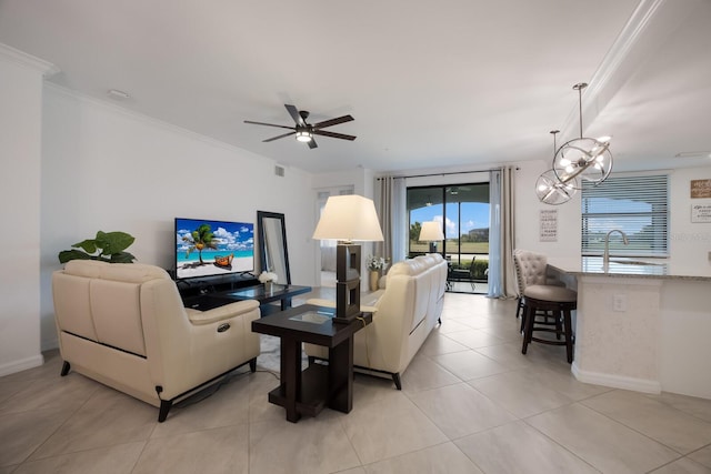 tiled living room with ceiling fan with notable chandelier, sink, and ornamental molding