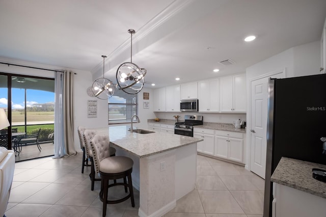 kitchen featuring white cabinetry, light stone countertops, appliances with stainless steel finishes, decorative light fixtures, and sink