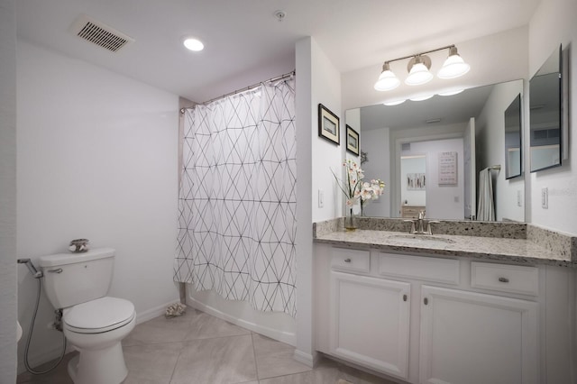 bathroom featuring vanity, toilet, and tile floors