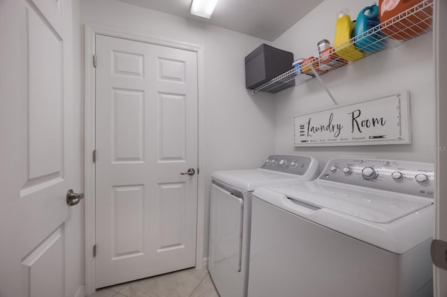 washroom with washer and dryer and light tile flooring