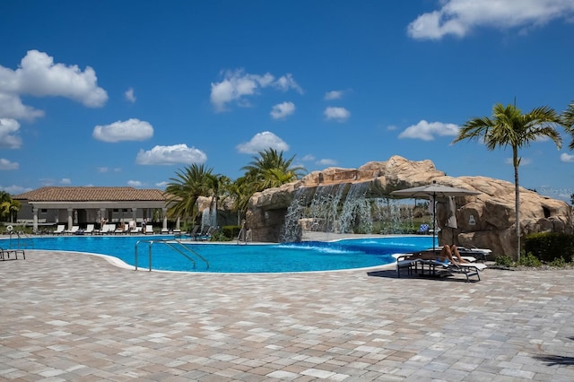 view of pool with a patio and pool water feature