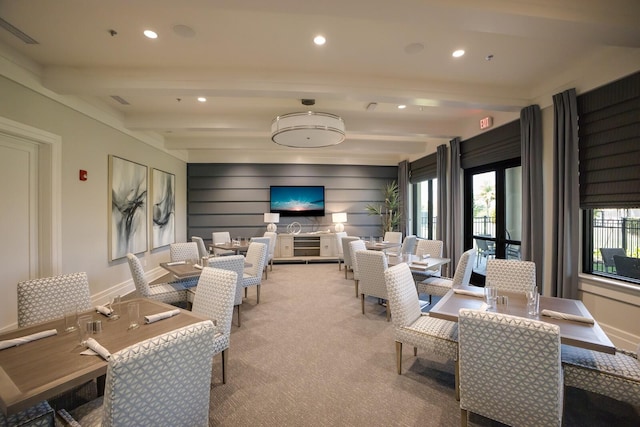 carpeted living room featuring beamed ceiling