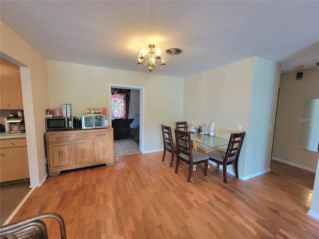 dining space with a chandelier and light wood-type flooring