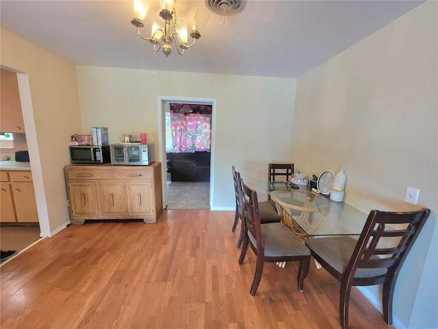 dining area with a chandelier and light hardwood / wood-style flooring