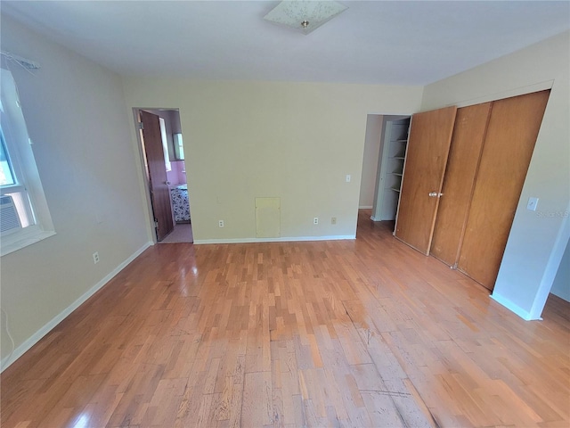 unfurnished bedroom with light hardwood / wood-style floors and connected bathroom