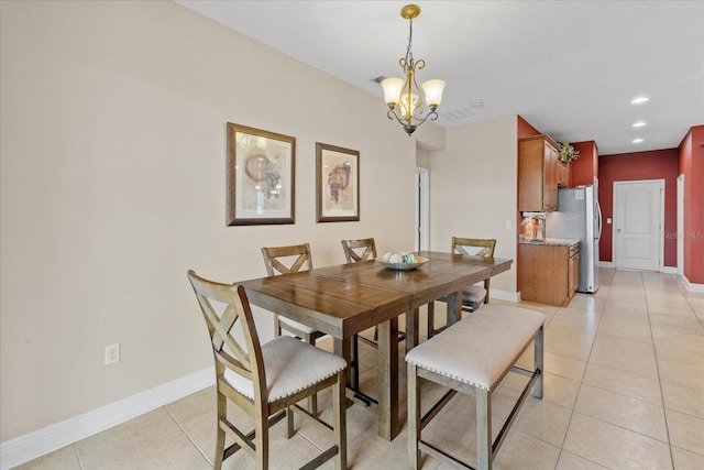 tiled dining space featuring a chandelier