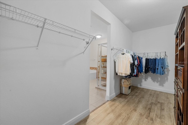 spacious closet with light hardwood / wood-style flooring