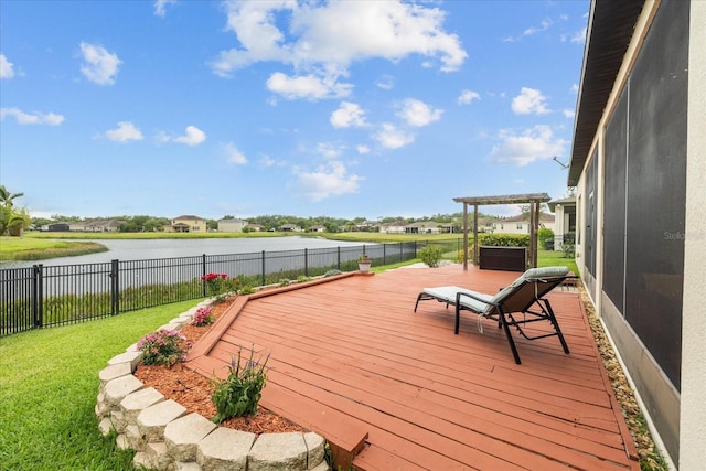 deck with a water view, a lawn, and a pergola