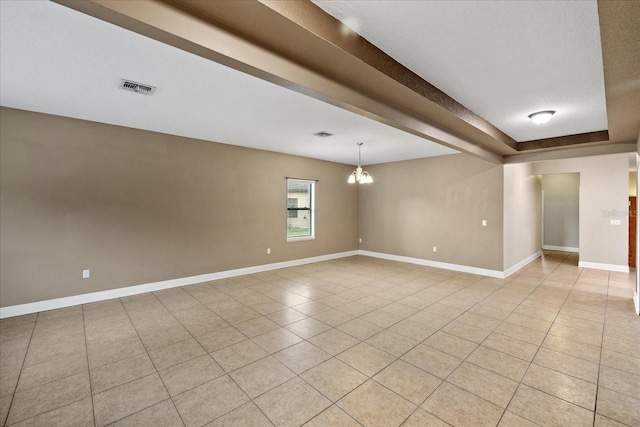 tiled empty room with a notable chandelier