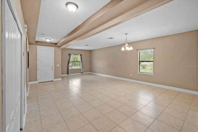 empty room featuring a notable chandelier and light tile patterned floors