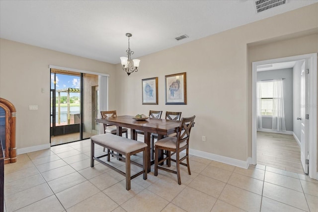 dining area featuring a chandelier and light tile patterned floors