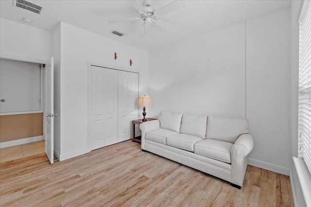 living room featuring light hardwood / wood-style floors, ceiling fan, and plenty of natural light