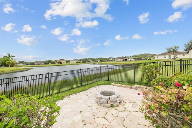 view of patio with a fire pit and a water view