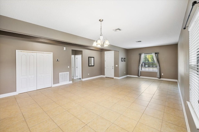 unfurnished room with light tile patterned flooring and a chandelier